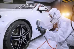 funilaria-e-pintura-automotiva-profissional-aplicando-tinta-em-carro-branco