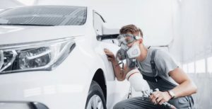 uma-pessoa-pintando-o-carro-de-branco-apos-a-funilaria