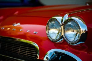 Detalhe-do-farol-cromado-de-um-carro-classico-vermelho-com-design-retro